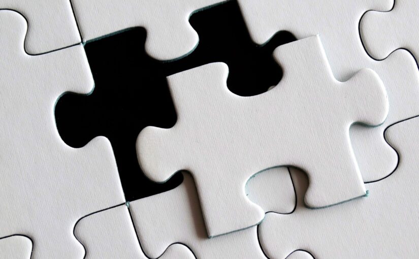 A white puzzle with one piece sitting outside of where it needs to go
